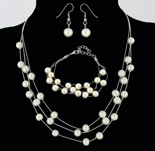 Elegant three-piece jewelry set with multi-strand pearl necklace, matching bracelet, and pearl drop earrings.