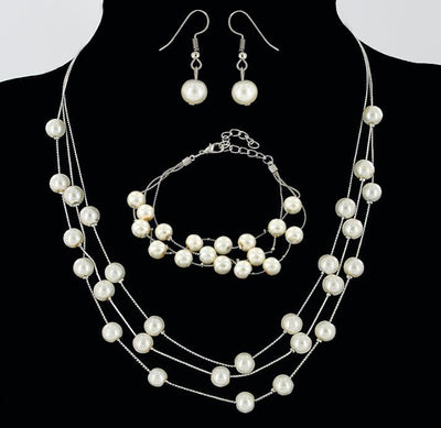 Elegant three-piece jewelry set with multi-strand pearl necklace, matching bracelet, and pearl drop earrings.