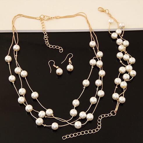 Elegant three-piece jewelry set with multi-strand pearl necklace, matching bracelet, and pearl drop earrings. - Image 3