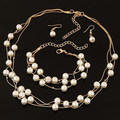 Elegant three-piece jewelry set with multi-strand pearl necklace, matching bracelet, and pearl drop earrings. - Image 2