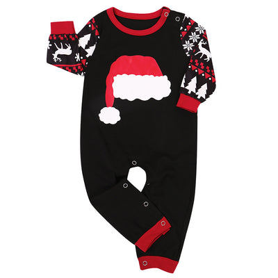 Family of four in black and red matching Christmas pajamas with Santa hat tops and fair isle pants. Also shown: a two-piece set and a baby romper. - Image 4