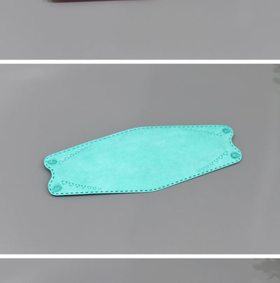 A fan of multi-colored KF94 fish-shaped masks in pink, blue, teal, white, gold, black, and grey, next to a packaged mask. - Image 13