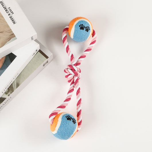 Red, pink, and white braided cotton rope dog toy with a green and red tennis ball featuring black paw prints. - Image 5