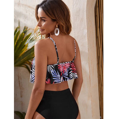 Women's split swimsuit with a black high-waisted bikini bottom and a flounced tankini top featuring a green, blue, and white tropical leaf print. - Image 4