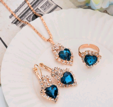 Rose gold-toned necklace, earrings, and ring set with large oval clear gemstones surrounded by smaller stones. - Image 16