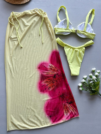 Woman in a light yellow three-piece bikini with an underwire top, matching bottoms, and a sheer floral sarong skirt. - Image 9
