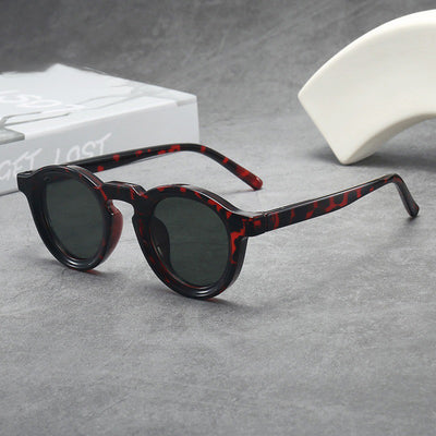 Vintage round frame sunglasses with black frames and pink lenses on a gray surface. - Image 18