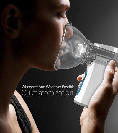 White and blue handheld ultrasonic nebulizer with a clear mask, emitting a blue light, against a bright blue sky. - Image 6