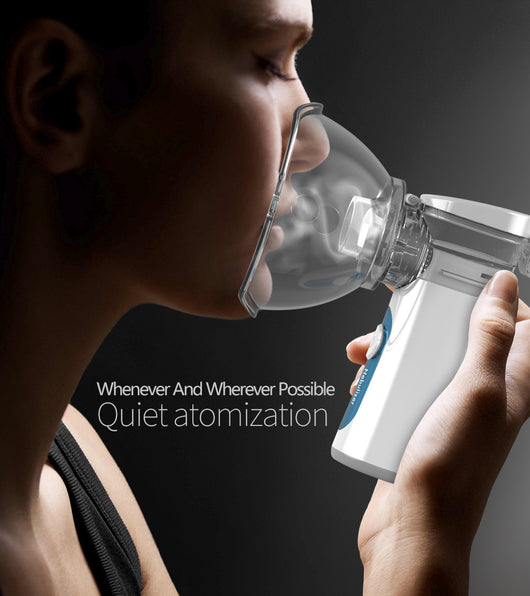 White and blue handheld ultrasonic nebulizer with a clear mask, emitting a blue light, against a bright blue sky. - Image 6