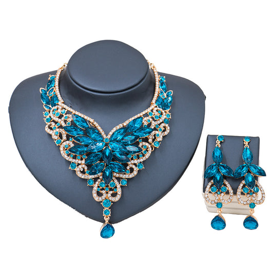 Exaggerated green gemstone necklace and matching dangle earrings set with gold-tone metal and clear accents. - Image 11