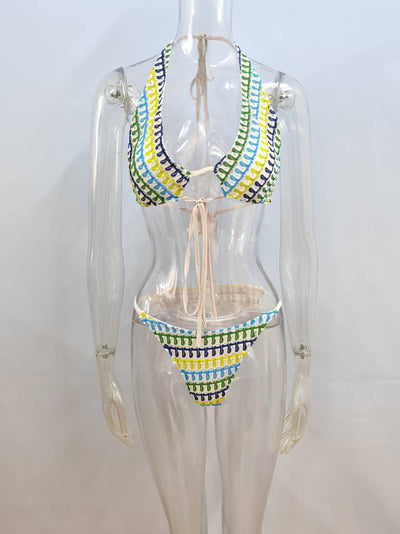 Woman in a blue, green, and yellow patterned halter bikini top and matching flowy sarong on a sunny beach. - Image 5
