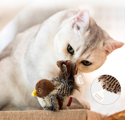 Silver tabby cat playing with a plush bird toy featuring brown and patterned feathers, a brown head, and a yellow beak. - Image 9