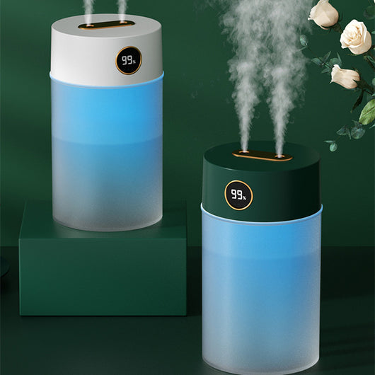 White cylindrical humidifier with a gold nozzle emitting mist, featuring a subtle bear emblem. Includes five aromatherapy oil bottles.