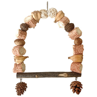 Natural wooden parrot swing with an arched top made of corn cobs, seed pods, and woven balls, featuring a log perch and two hanging pine cones. - Image 6