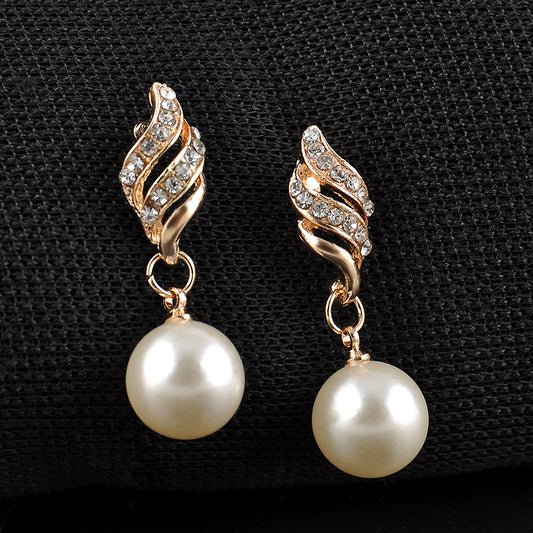 Gold-tone necklace and dangle earring set with faux pearls and clear rhinestones, displayed on a black bust.