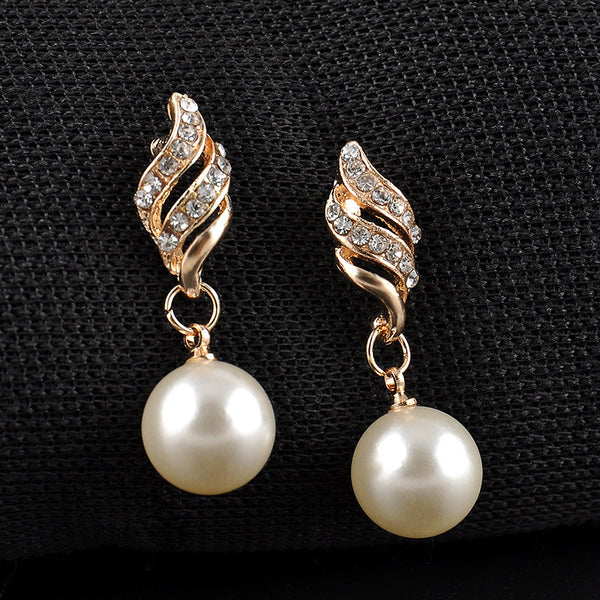 Gold-tone necklace and dangle earring set with faux pearls and clear rhinestones, displayed on a black bust.
