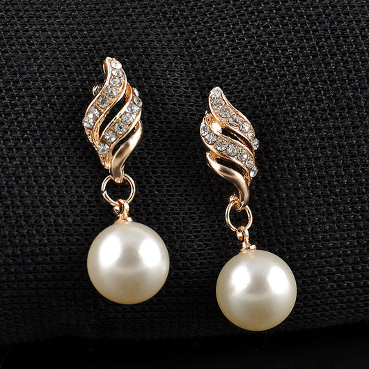 Gold-tone necklace and dangle earring set with faux pearls and clear rhinestones, displayed on a black bust.