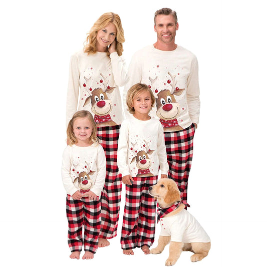 Family of four and a golden retriever puppy wearing matching cream reindeer print and red plaid Christmas pajamas.