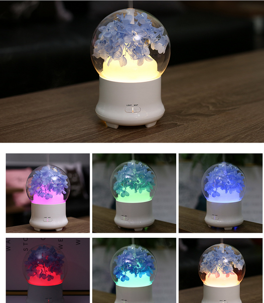 White aromatherapy machine with a clear dome top, featuring blue preserved flowers and an aqua glow. Includes 'LIGHT' and 'MIST' controls. - Image 4
