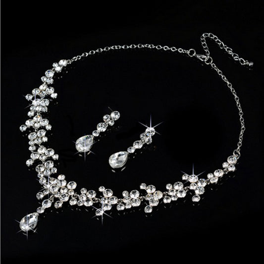 Sparkling silver-tone rhinestone necklace and matching teardrop earrings set on a black background. - Image 2