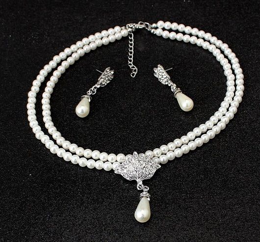 Two-strand white pearl necklace with a crystal fan pendant and matching teardrop pearl drop earrings.