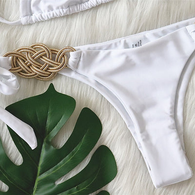 White two-piece bikini with gold braided knot details on the halter straps and tie-side bottom, laid flat. - Image 21