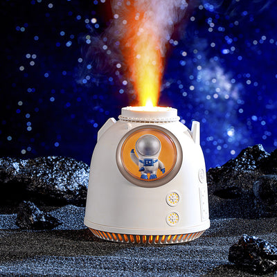 White spaceman humidifier with an orange-lit window featuring a small astronaut figure and a glowing top light.