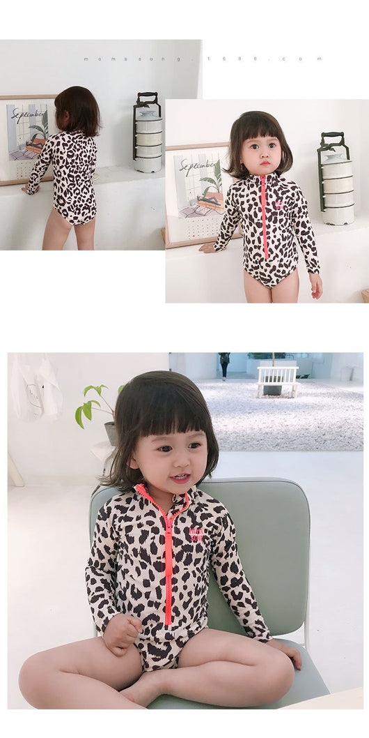 Child's long-sleeve leopard print swimsuit with a coral zipper and a matching swim cap on a white background. - Image 10