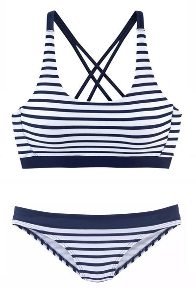 Woman smiling on a beach wearing a navy and white striped two-piece bikini with a racerback top. - Image 3