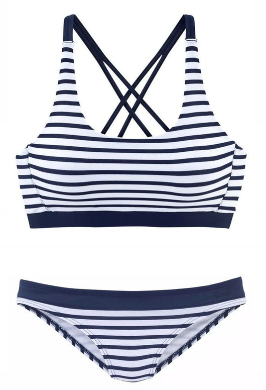 Woman smiling on a beach wearing a navy and white striped two-piece bikini with a racerback top. - Image 3