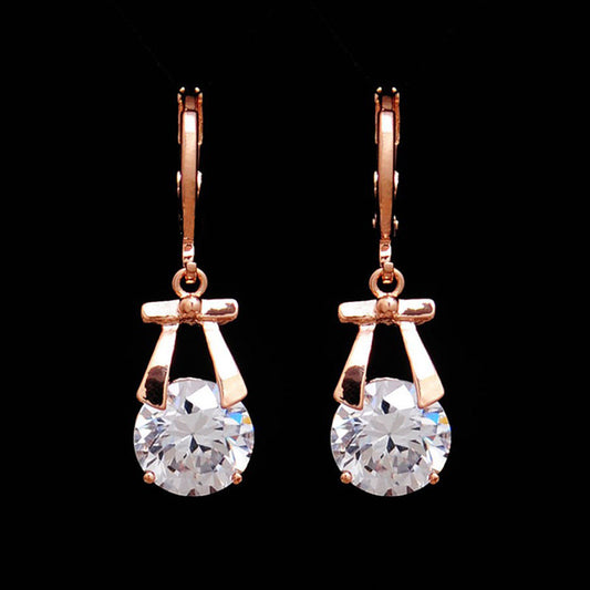 Rose gold-toned jewelry set with a necklace and matching dangle earrings, each featuring a round clear crystal. - Image 2