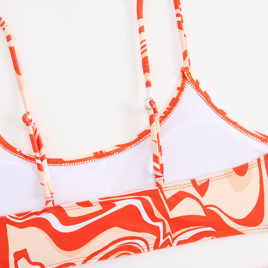 Red, orange, and white abstract swirl print three-piece bikini set with matching shorts, shown with a straw hat and sunglasses. - Image 13