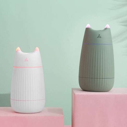 Pink cat-shaped humidifier with pointed ears and a ribbed texture on the lower body, ideal for desktop use.