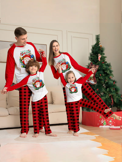 Man in a red and white Christmas pajama set with a Santa Claus graphic top and red and black plaid pants. - Image 6