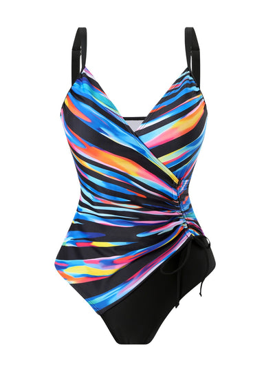 Woman in a navy and white striped tankini swimsuit with a wrap-front and side drawstring, holding a woven bag. - Image 27