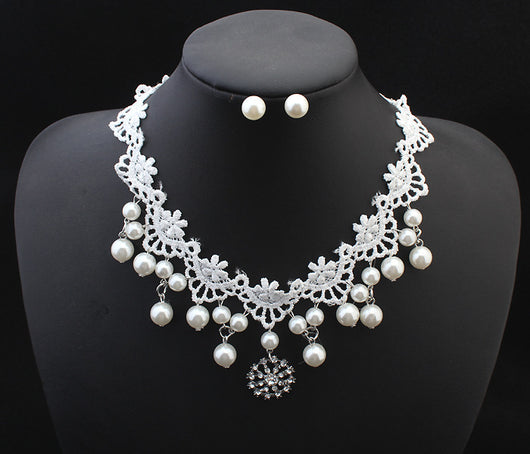 White lace choker necklace with dangling faux pearls and a central rhinestone pendant on a black jewelry bust. - Image 5