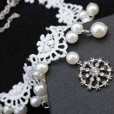 White lace choker necklace with dangling faux pearls and a central rhinestone pendant on a black jewelry bust. - Image 4