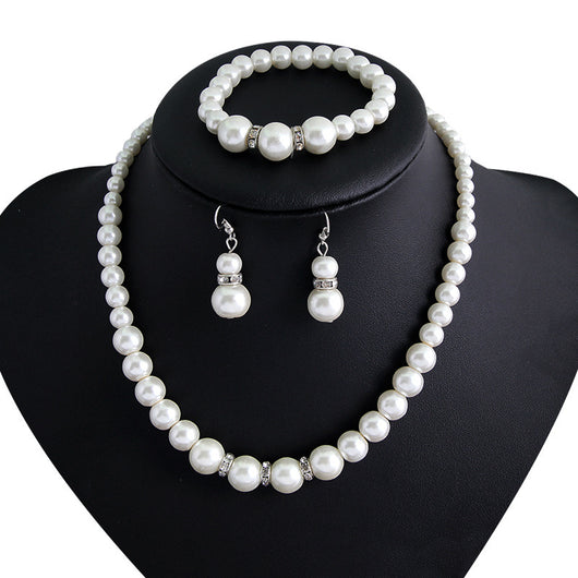 Three-piece white faux pearl jewelry set with rhinestone accents, including a necklace, drop earrings, and a bracelet. - Image 3