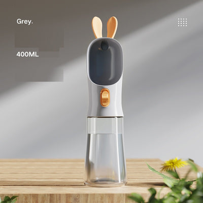 Grey and white portable pet water bottle with clear reservoir, built-in drinking bowl, and decorative bunny ears. - Image 4
