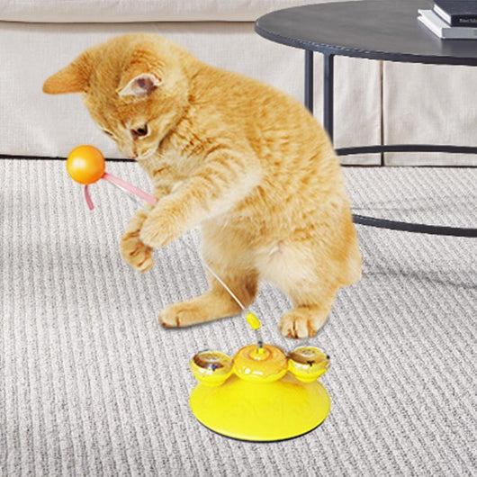 Tabby cat playing with a yellow suction cup cat toy featuring a spring-mounted teaser wand with an orange fur ball. - Image 2