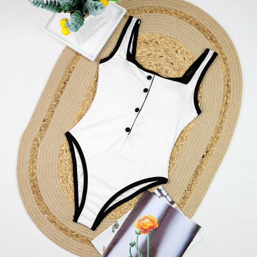 Woman in a white one-piece swimsuit with black trim and decorative buttons, sitting on a boat. - Image 14