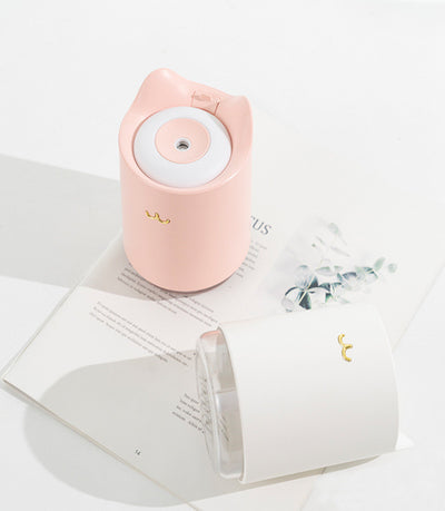 White mini USB humidifier with cat ears and a gold cat nose/mouth emblem, featuring a clear water tank base. - Image 3