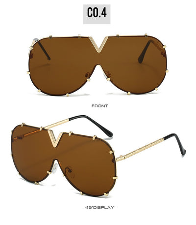 Oversized V-shaped sunglasses with a gold metal frame, white accents, clear lenses, and decorative rivets. - Image 13
