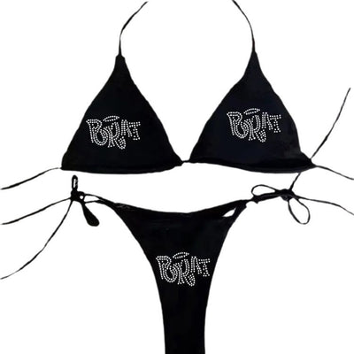 Black halter bikini with rhinestone 'BRAT' lettering on triangle top and tie-side bottom, displayed on white faux fur. - Image 4