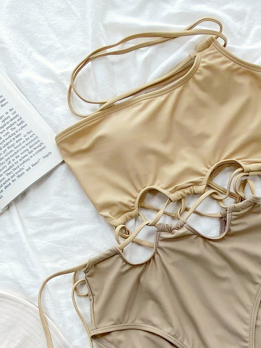 Beige solid color one-piece swimsuit with an asymmetrical neckline, tie-shoulder straps, and criss-cross side cutouts. - Image 4