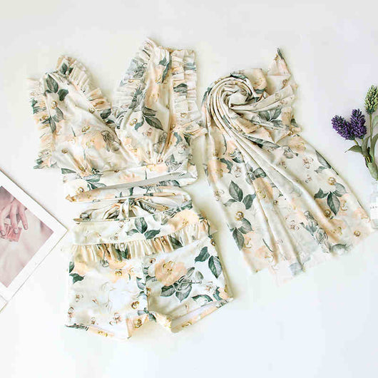 Women's three-piece swimwear set with a cream floral print, ruffled crop top, high-waisted shorts, and matching sarong. - Image 7