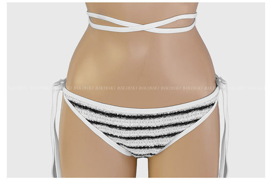 White and black striped bikini with triangle-cut top and tie-side bottom, modeled outdoors. - Image 29