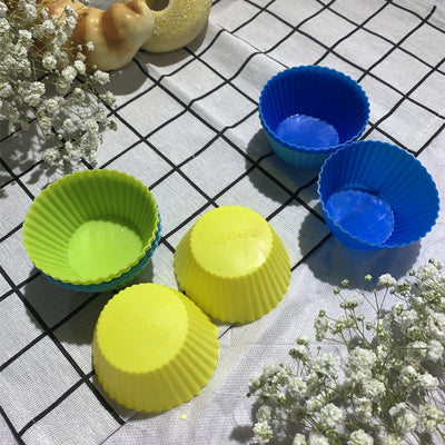 Six colorful silicone cupcake liners in red, blue, hot pink, yellow, pink, and lime green on a white background.