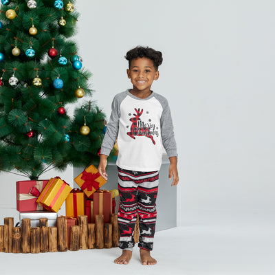Woman wearing a white and grey long-sleeve Christmas pajama top with a plaid reindeer and patterned holiday pants. - Image 7