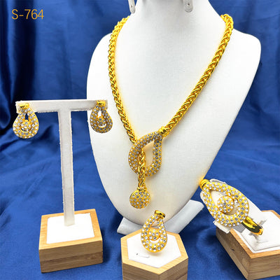 Gold-plated four-piece jewelry set with teardrop rhinestone necklace, bracelet, earrings, and ring on red velvet stands. - Image 3